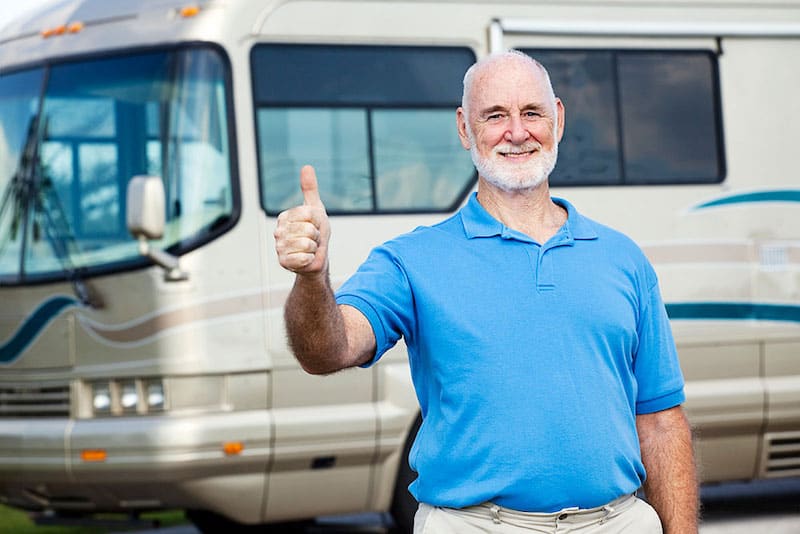 Man standing in front of an RV giving a thumbs up - RV packing tips