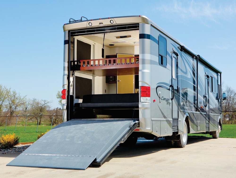 picture of a toy hauler Class A motorhome with the back ramp down to access the rear garage.